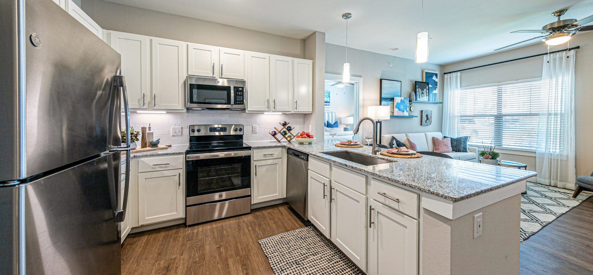 Hawthorne at Bay Forest apartment gourmet kitchen interior with breakfast bar, stainless steel appliances, and granite countertops